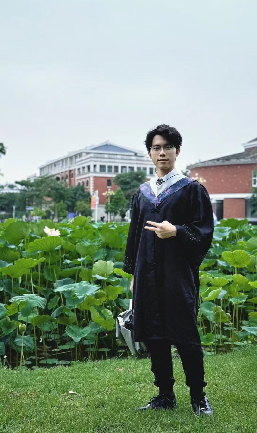 Graduation photo beside lotus flowers at Xingyu Lake.