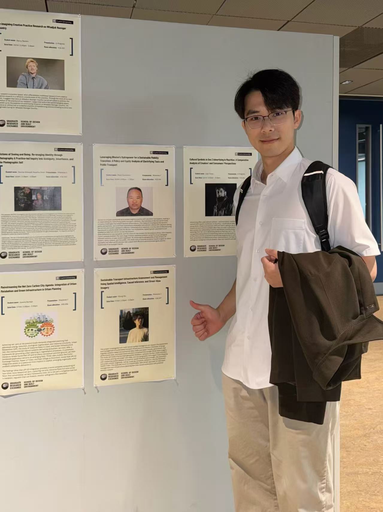 Yilong Wu beside his research poster on the Graduate Research Exchange poster wall in Building 418.