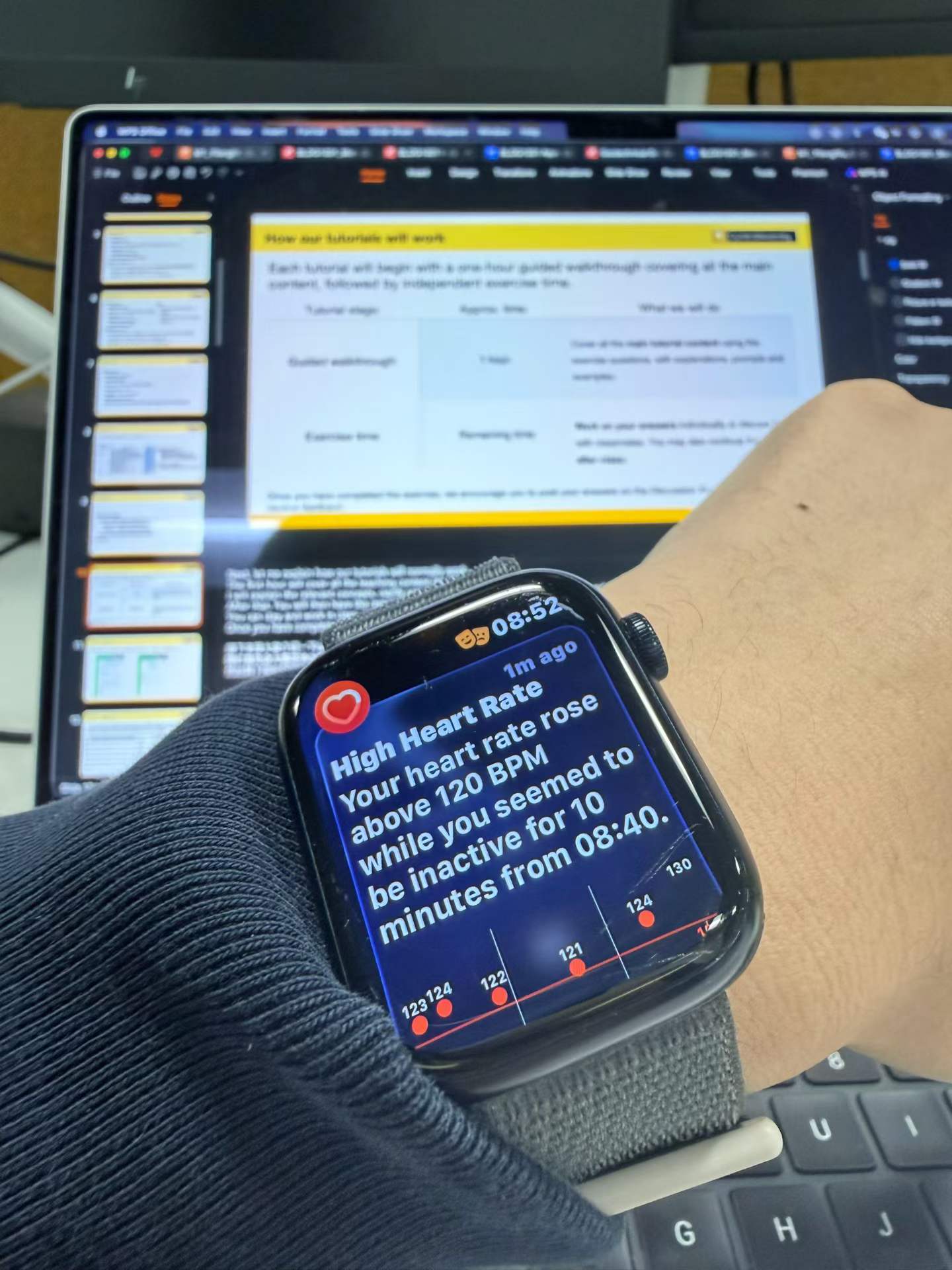 A high heart rate notification on a watch in front of the tutorial slides before class.