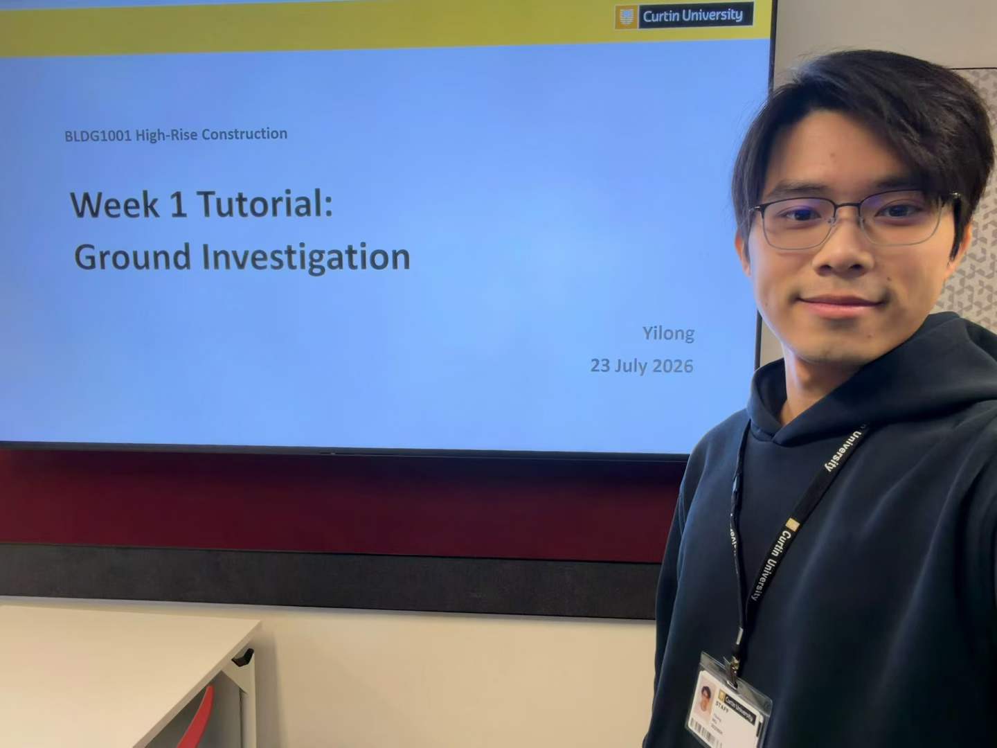 Yilong Wu beside the Week 1 Ground Investigation tutorial slide for BLDG1001 High-Rise Construction at Curtin University.