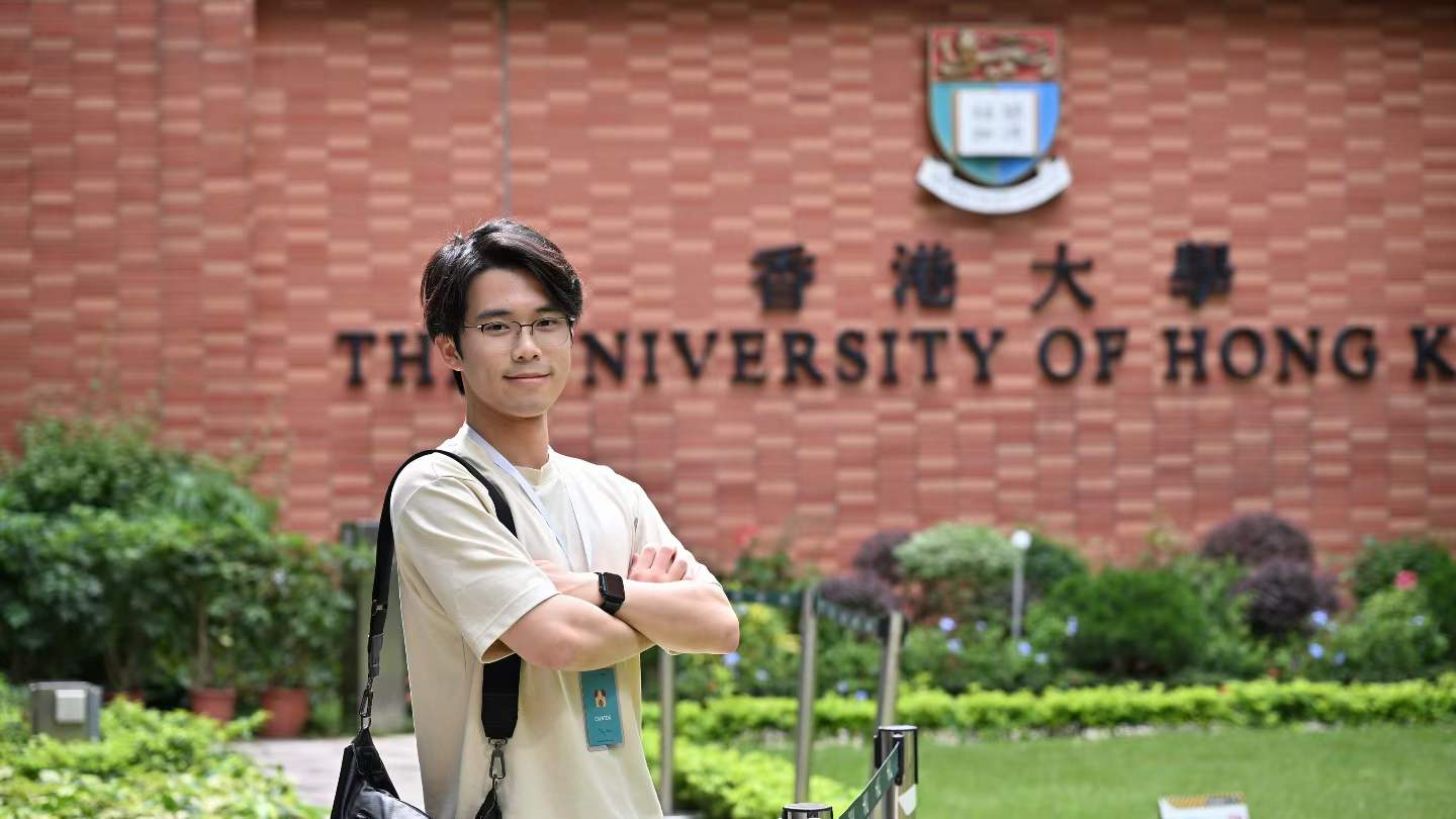 Yilong Wu in front of the University of Hong Kong sign.